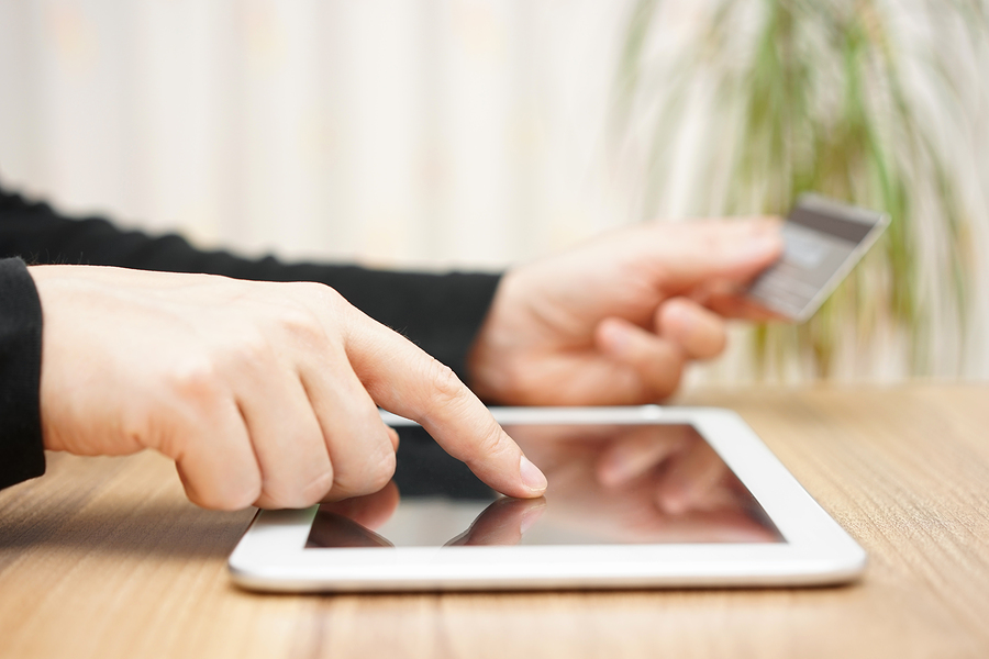 Man is using credit card for on line payment on tablet computer